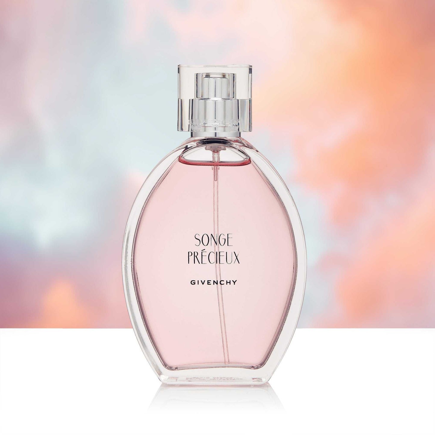 Perfume bottle against a serene peach and blue sky backdrop.