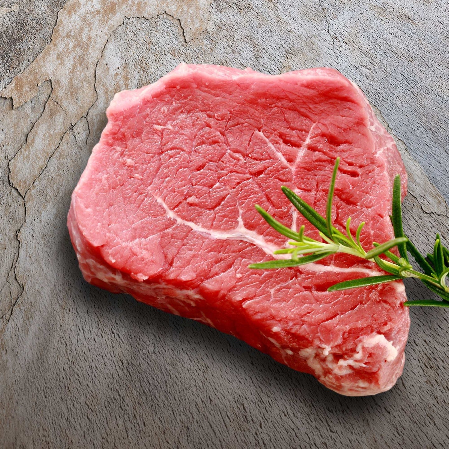 Raw steak on Worn Patina backdrop with cracked, textured surface.