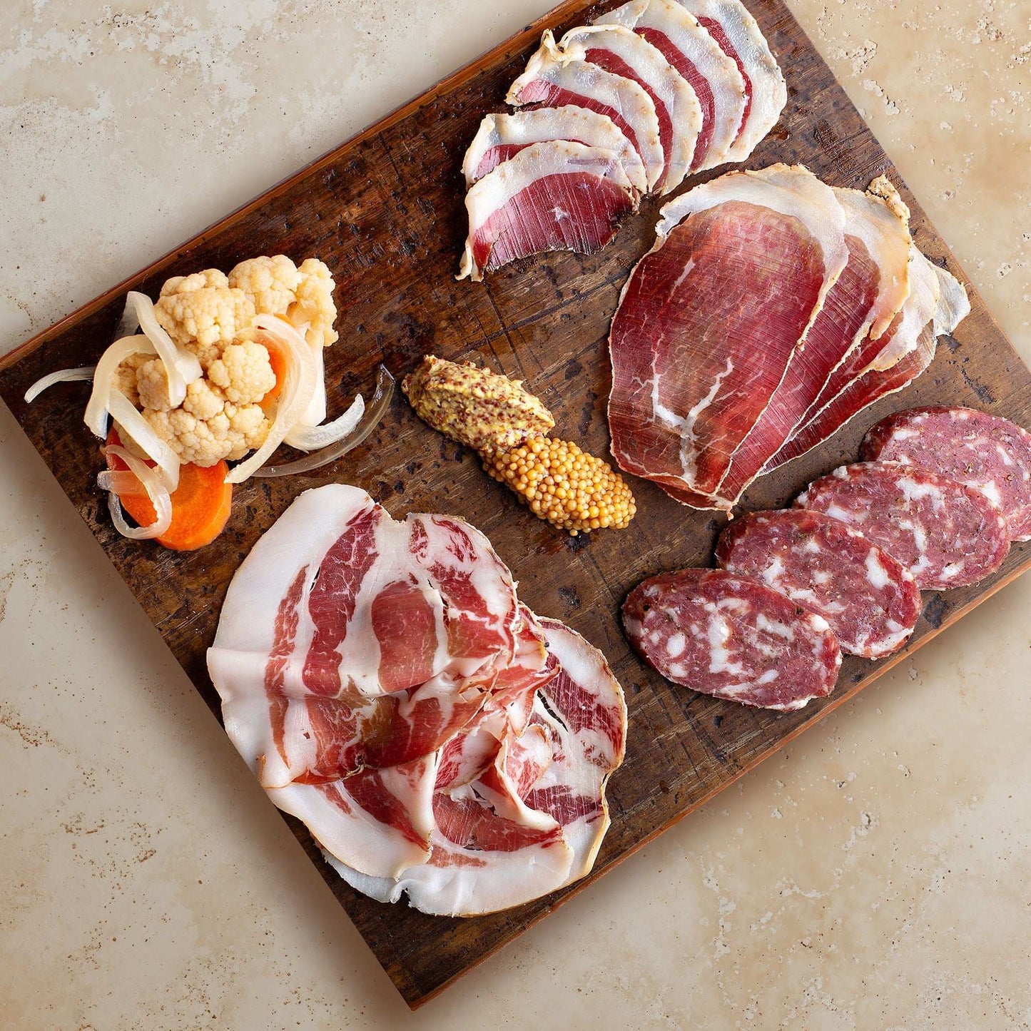 Sandstone Veil backdrop behind charcuterie board with meats and pickles.